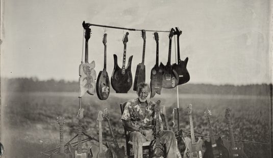 Freeman and his guitars, in the tobacco field outside his home, 2016.